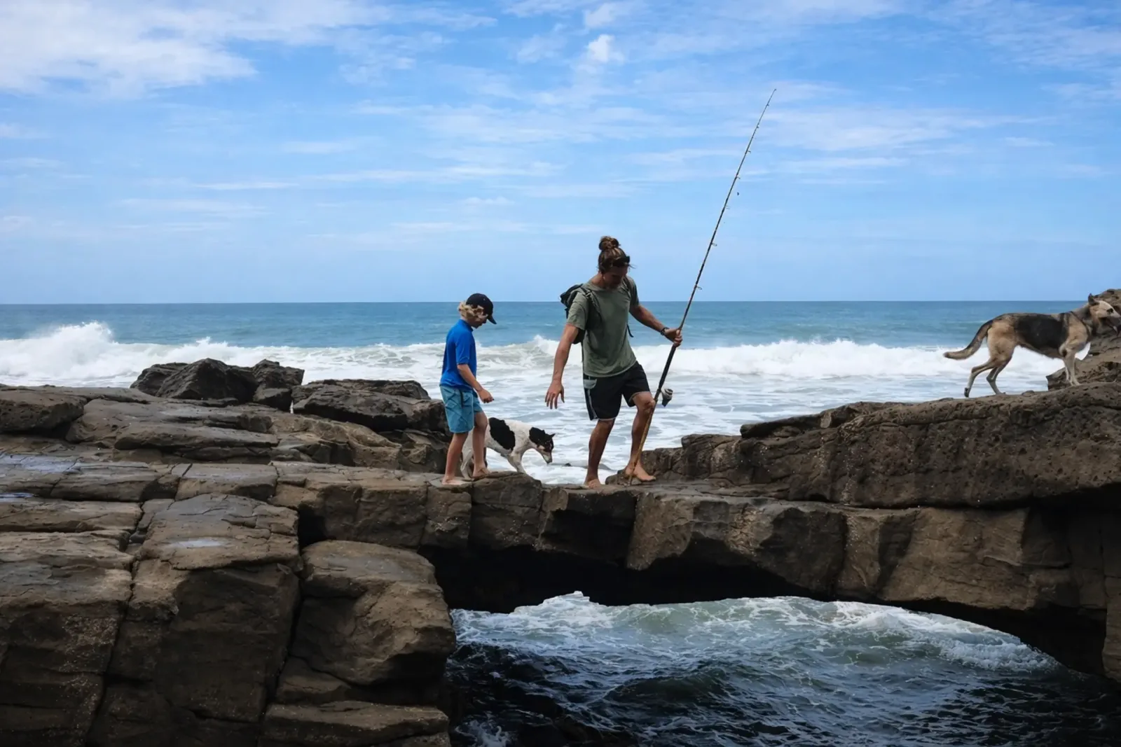 Father and son fishing from the rocks by the ocean near Popoyo, Tola, Nicaragua